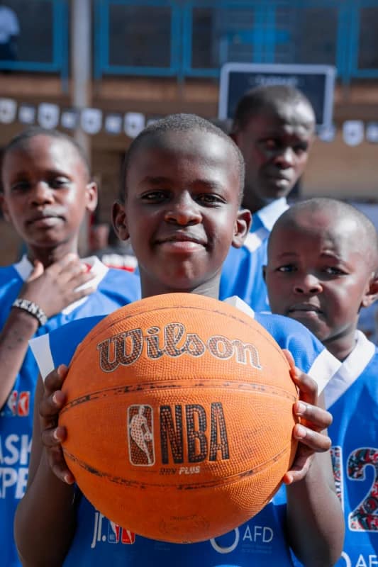 Basketball Experience Clinic for Deaf and Non-Deaf Students Lights Up Kinyanjui Road Primary School 3 A student poses with a basketball during the basketball clinic at Kinyanjui Road Primary School